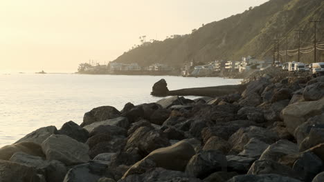 Reminiscing-on-the-rocky-stone-shoreline-of-Big-Rock-beach-Malibu-next-to-a-edge-road-at-golden-hour