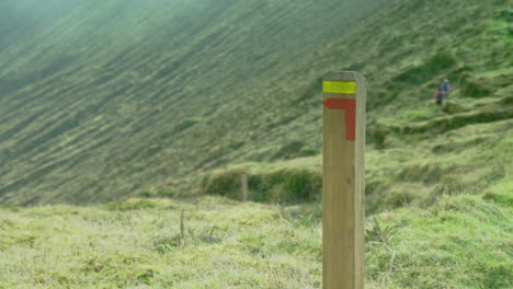 A-trail-marker-post-with-soft-focus-joggers-in-the-background