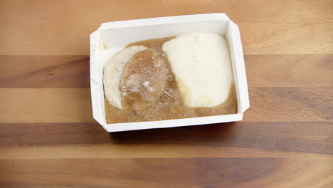 Frozen-food-in-a-meal-packed-container-melting-at-room-temperature-on-a-dining-table