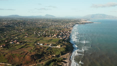 Aerial-View-Of-Ocean-Waves-Crashing-On-The-Coastline-Of-Terrasini-Town-In-Palermo,-Sicily,-Italy