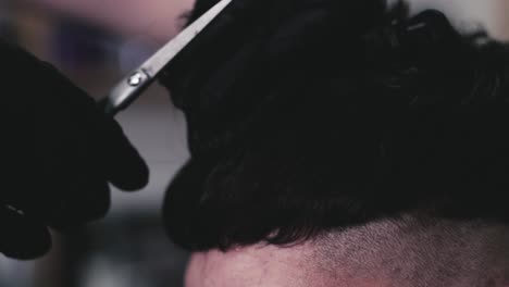 Cutting-the-hair-of-a-male-client-with-scissors-in-a-barbershop-by-a-barber