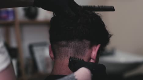 Barber-cutting-short-the-hair-of-a-guy-using-clippers