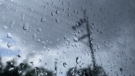 Rainy-fall-autumn-season,-looking-out-window,-depressing-water-drops,-grey-sky