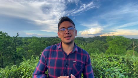 A-blogger-from-Bangladesh-speaking-in-camera-with-beautiful-natural-forest-background