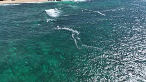 Windsurfers-and-wing-foilers-riding-cross-onshore-wind-back-forth,-Hookipa-Maui