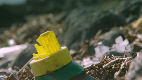 Focus-pull-from-plastic-rubbish-to-a-broken-plastic-bottle-on-the-beach