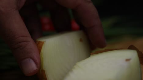 Slow-motion-close-up-shot-as-a-hand-turning-onions-cut-in-half,-preparing-ingredients,-process-fo-further-preparation-to-cook