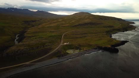 Aerial-landscape-view-of-Iceland-north-coast,-with-ocean-waves-crashing-on-the-shoreline,-at-dusk
