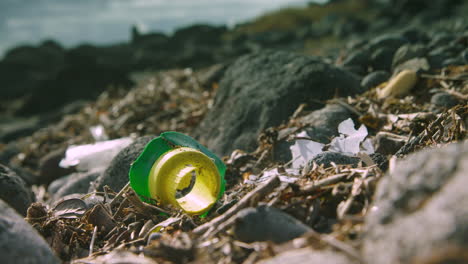 Broken-plastic-waste-lies-washed-up-on-a-beach