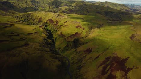 Aerial-landscape-view-of-a-river-flowing-in-a-mountain-canyon,-in-Iceland