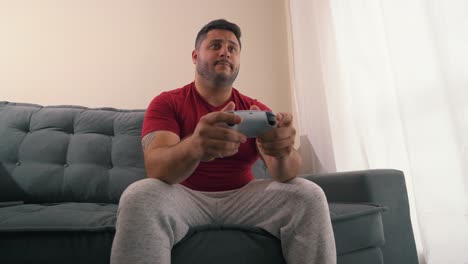 Confident-man-celebrating-achievment-playing-video-games-with-console-controller-in-his-hands