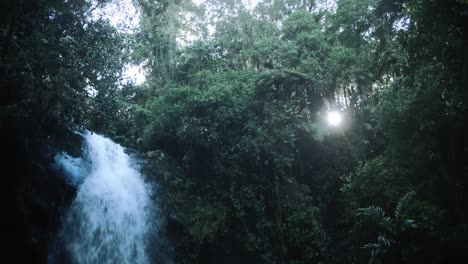 Ein-Wasserfall-Und-Die-Sonne-Scheint-Durch-Die-Bäume-In-Einem-Regenwald
