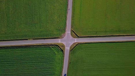 Spiral-drone-view-of-a-crossroad-with-1-car-passing