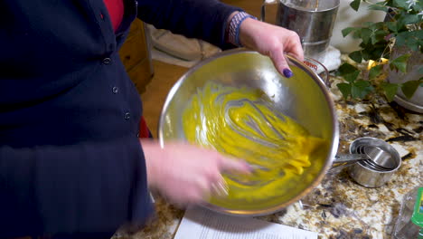 Skilled-woman-hand-whisking-egg-yolks---close-up
