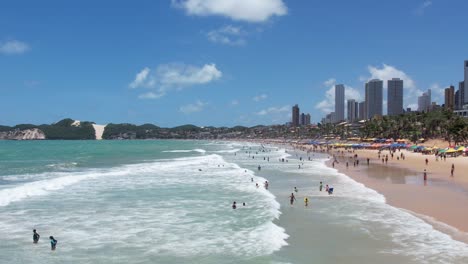 Crowded-beach-shore,-Aerial-view-people-on-shore-waves,-Ponta-preta,-Natal