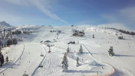 4K-Drohne-Fliegt-über-Einen-Belebten-Schneebedeckten-Hang-In-Den-Französischen-Alpen,-Flachau,-Österreich