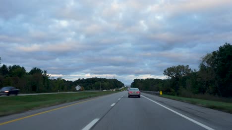 POV-shot-taken-while-driving-fast-along-highway-road-on-a-cloudy-day