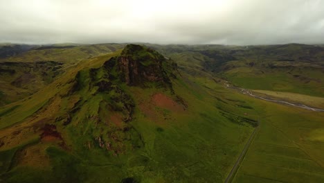 Aerial-panoramic-landscape-view-of-Iceland-mountain-grasslands,-on-a-cloudy-day