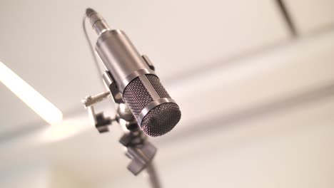 Cierre-A-Mano-Ajustando-El-Micrófono-En-Un-Estudio-De-Grabación-Profesional