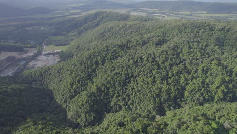 Flying-Over-Lush-Green-Hills-In-Port-Douglas,-Far-North-Queensland,-Australia---aerial-drone-shot