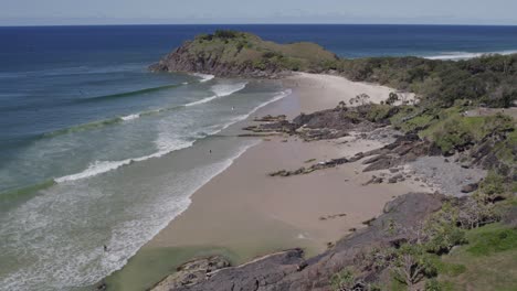 Ocean-Waves-Splashing-On-Sandy-Shore-At-Cabarita-Beach-In-NSW,-Australia---aerial-pullback