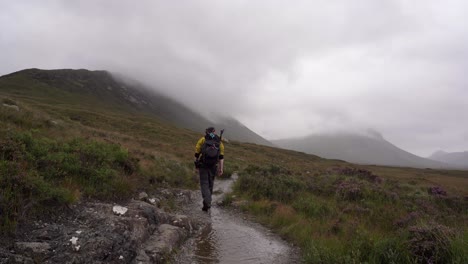 Mann-Mit-Gelber-Jacke,-Der-Durch-Einen-Nebligen-Isle-Of-Skye-Trail-Wandert