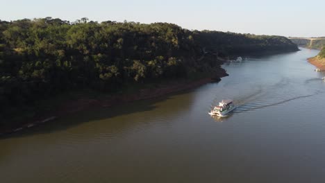 Barco-Turístico-Navegando-Por-El-Río-Iguazú-Navegable-En-La-Frontera-Entre-Argentina-Y-Brasil-Al-Atardecer