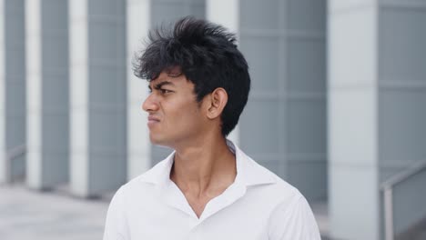 Portrait-shot-of-Young-Indian-male-confused-and-Puzzled,-businessman-considering-difficult-decisions-outdoors