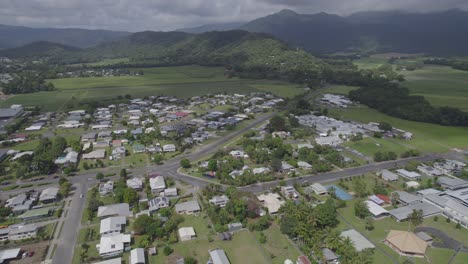 Mossman-Town-Surrounded-With-Green-Fields-And-Mountains-In-The-Shire-of-Douglas,-Queensland,-Australia---aerial-drone-shot