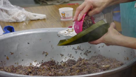 Schüssel-Mit-Heißer-Violetter-Reismischung,-Die-In-Blattverpackung-Gelegt-Und-Von-Hand-Gefaltet-Wird
