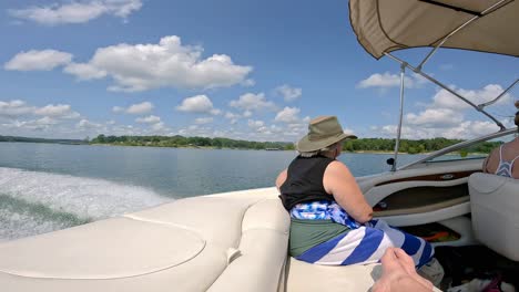 Slow-motion-of-woman-watching-passing-scenery-of-Table-Rock-Lake-in-Missouri-USA-while-sitting-in-back-of-sports-boat-on-a-sunny-afternoon