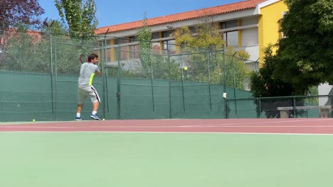 Hübscher-Männlicher-Tennisspieler,-Der-Tennisball-Mit-Schläger-Draußen-Auf-Tennisplatz-In-Lissabon-Schlägt