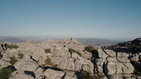 Aerial-drone-rotating-shot-over-eroded-rocky-mountain-range-in-Torcal-de-Antequera,-Spain-seen-from-above-during-evening-time