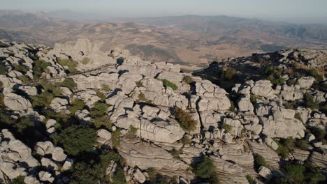 Aerial-drone-tilt-down-shot-over-Karst-rocky-landscape-in-the-Torcal-de-Antequera,-Malaga,-Andalusia,-Spain,-during-evening-time