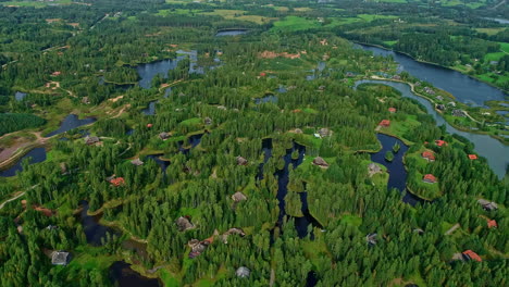 Verdant-landscape-with-luxury-villas-immersed-in-lush-nature-of-forest-and-lakes,-Amatciems-eco-village-in-Latvia