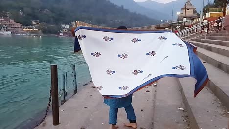 young-girl-enjoying-at-river-shore-at-sunset-from-flat-angle-video-is-taken-rishikesh-uttrakhand-india-on-Mar-15-2022