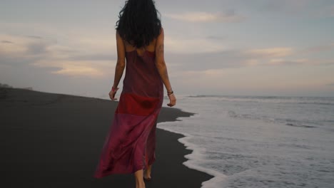 Attractive-Woman-In-Red-Dress-Walking-In-The-Beach-With-Crashing-Waves