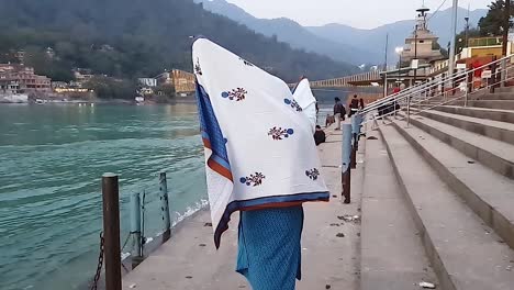 young-girl-enjoying-at-river-shore-at-sunset-from-flat-angle-video-is-taken-rishikesh-uttrakhand-india-on-Mar-15-2022