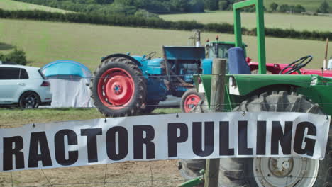 Tractor-Pulling-Sign-On-Wire-Fence-With-Old-Tractors-Inside
