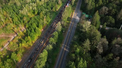 Aerial-view-looking-down-at-trains-passing-through-Baring,-Washington-on-a-bright-sunny-day