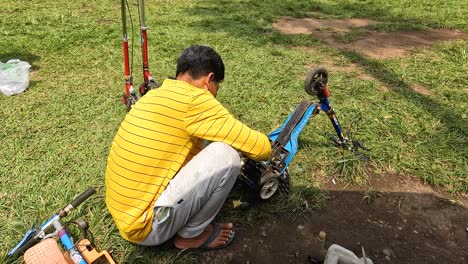 Portrait-of-man-repairing-bicycle-for-children-in-backyard