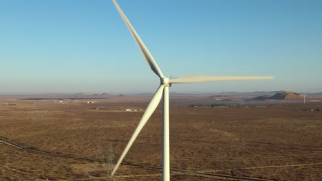 Isolated-close-up-of-a-wind-turbine-spinning-to-generate-clean,-renewable-energy-in-the-Mojave-Desert,-aerial-view