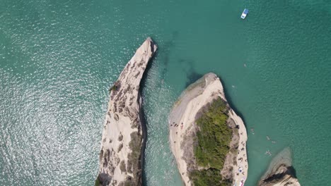 Topdown-view-of-Boats-on-Emerald-clear-water,-revealing-Canal-d´amour-rock-formation-in-Sidari,-Corfu
