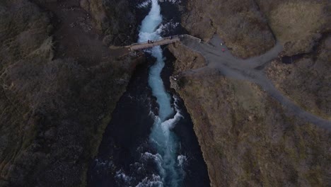 Drone-flying-over-Bruararfoss-waterfall-in-rural-landscape,-Iceland