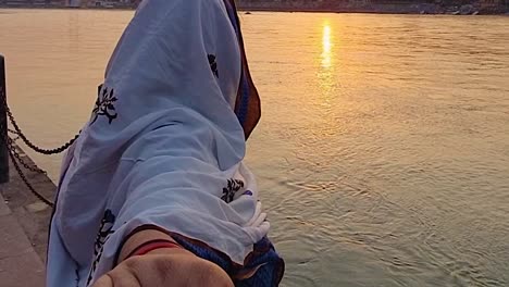 couple-holding-each-other-at-river-shore-at-sunset-from-flat-angle-video-is-taken-rishikesh-uttrakhand-india-on-Mar-15-2022