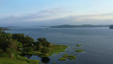 Beautiful-rotating-aerial-drone-shot-of-the-stunning-man-made-Guarapiranga-Reservoir-in-the-south-part-of-São-Paulo,-Brazil-near-Interlagos-with-beaches,-marinas,-and-wildlife-on-a-fall-evening