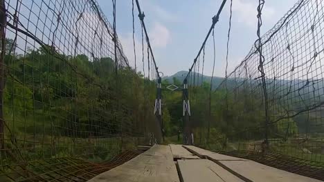 Ein-Mann,-Der-An-Einer-Vintage-Eisenhängebrücke-Aus-Einem-Niedrigen-Winkelvideo-Spazieren-Geht,-Wird-In-Nongjrong-Meghalaya,-Indien,-Aufgenommen