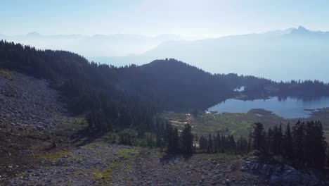 Elegante-Luftdrohnenaufnahme-Des-Bergspitzensees-Und-Des-Dunstigen-Landschaftshintergrunds-Auf-Dem-Mount-Brew-Canada-4k