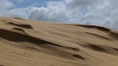 Erstaunliche-Nahaufnahme-In-Zeitlupe-Von-Wind,-Der-Sand-Von-Der-Spitze-Einer-Sanddüne-Weht