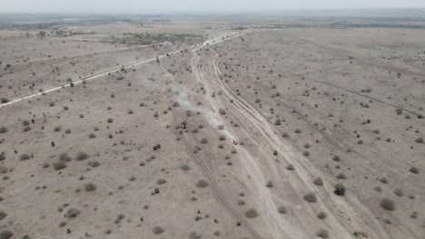 Aerial-view-of-a-truck-driving-Through-The-Dusty-Desert